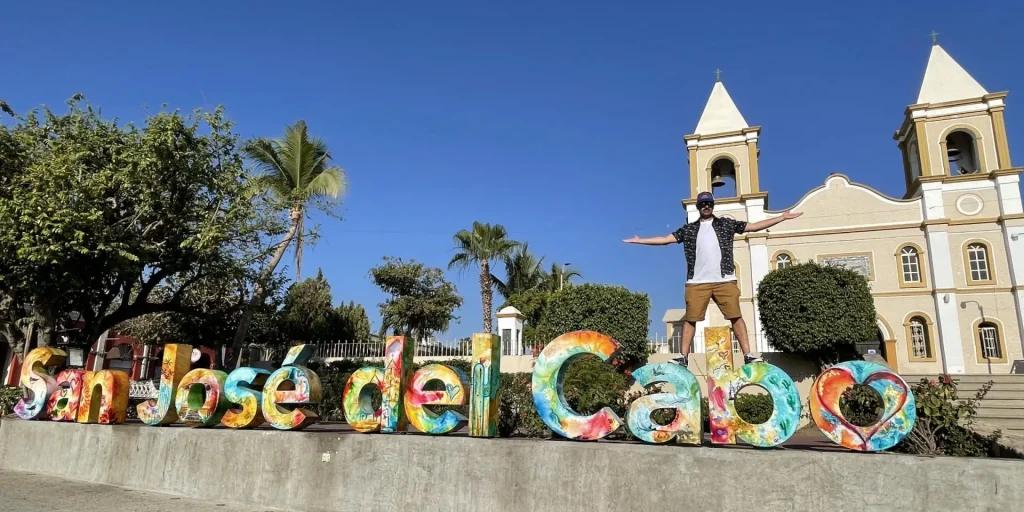 Miguelito de Two on Trip posando junto al colorido letrero de San José del Cabo.