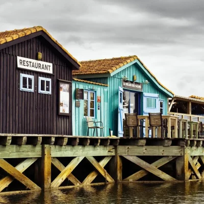 Casas ostrícolas de colores en la isla de Oléron, Francia, junto al agua y con un restaurante tradicional.