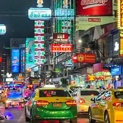 Ana explorando las calles nocturnas de Bangkok, rodeada de luces de neón