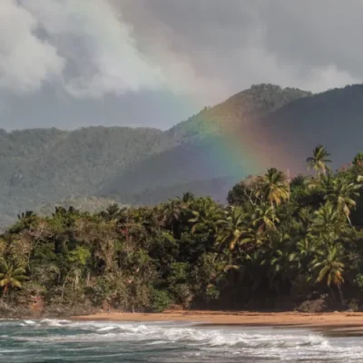Arcoíris sobre Playa Lanza del Norte en Samaná, República Dominicana, con palmeras y montañas