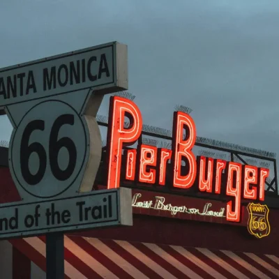 Cartel del final de la Ruta 66 en California, con el icónico Pier Burger iluminado