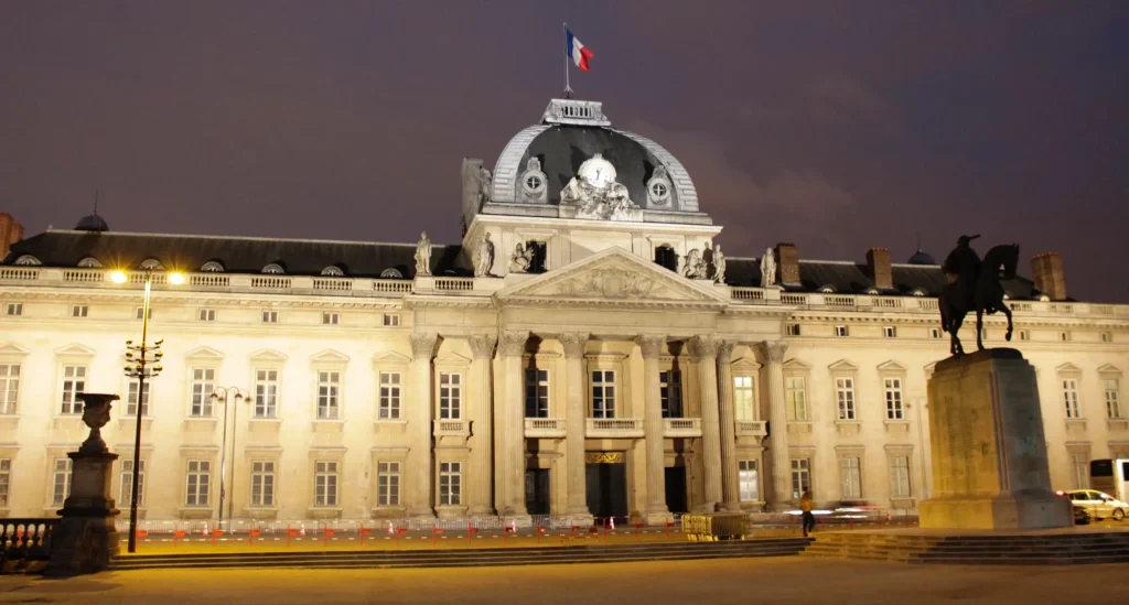 Fachada iluminada de la Escuela Militar de París bajo el cielo nocturno