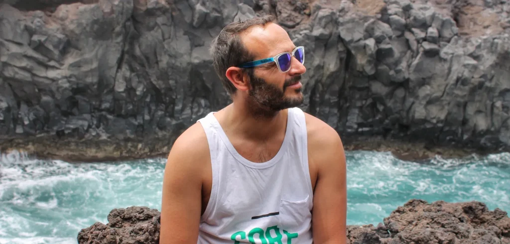 Miguelito de Two on Trip en Los Hervideros de Lanzarote con el mar golpeando la roca volcánica