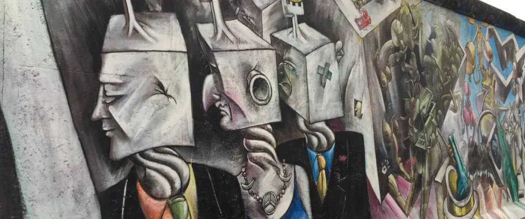 Grafiti impactante del Muro de Berlín con figuras surrealistas en la East Side Gallery
