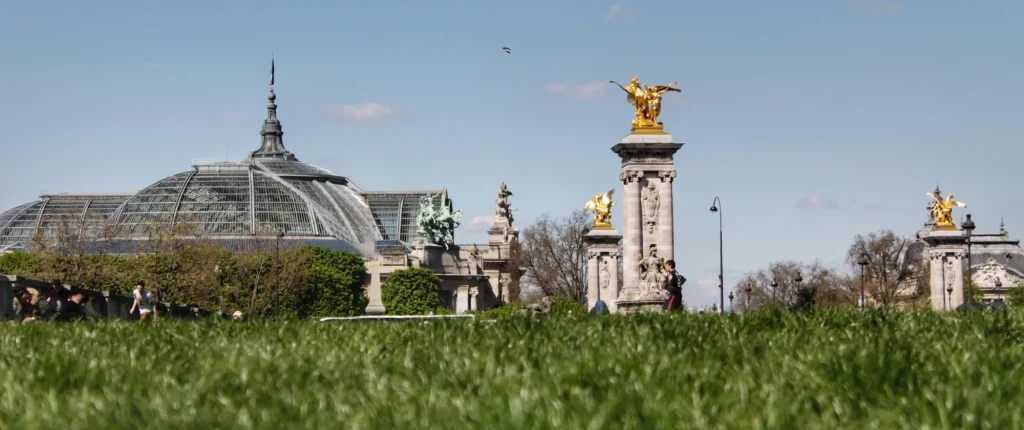 Vista del Puente Alexandre III en París con cielo azul y césped primaveral