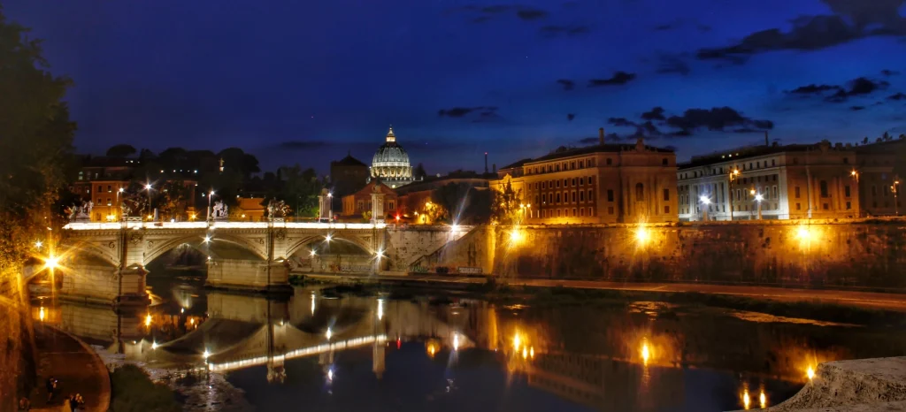 Vaticano iluminado de noche desde el río Tíber, una postal mágica de Roma
