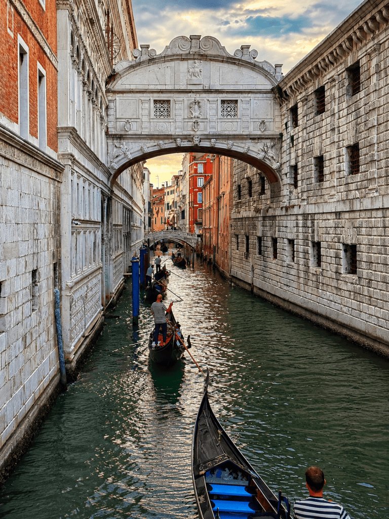 Puente de los Suspiros con varias góndolas navegando por el canal en Venecia