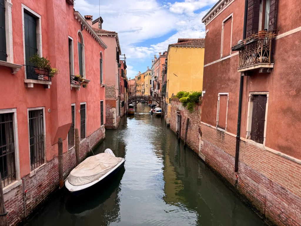 Canal del centro histórico de Venecia rodeado de edificios tradicionales y pequeñas embarcaciones