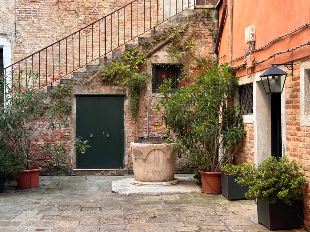Rincón típico del centro histórico de Venecia con un antiguo pozo de piedra y edificios tradicionales