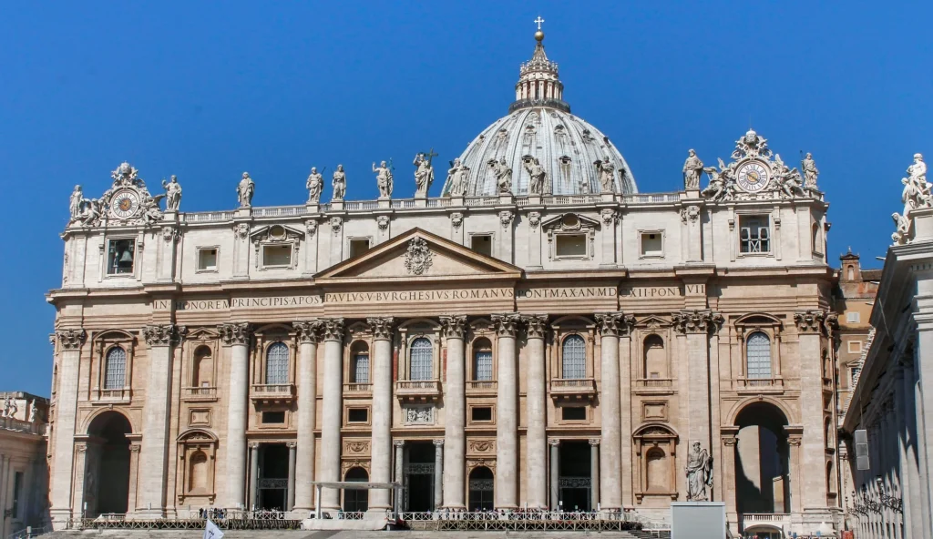 Fachada imponente de la Basílica de San Pedro en el Vaticano iluminada por el sol