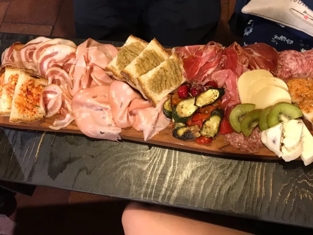 Tabla brutal de embutidos y quesos en Roma, con pan, frutas y delicias locales